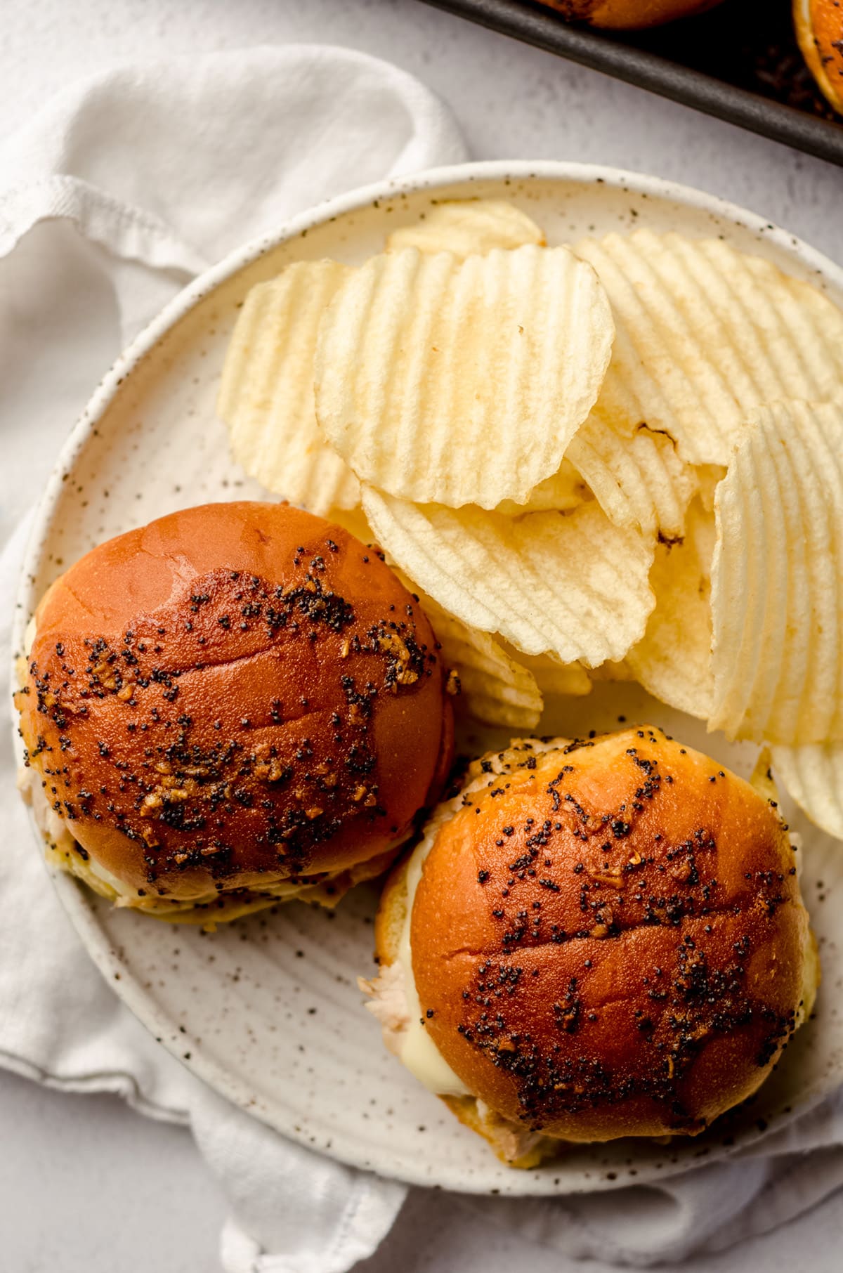 aerial photo of turkey and cheese sliders on a plate with potato chips