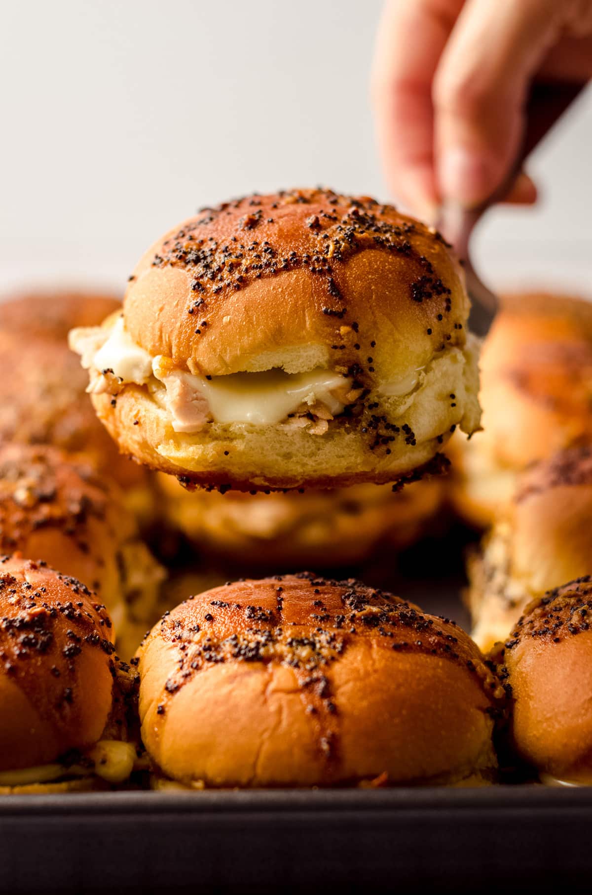 serving baked turkey sliders with a spatula