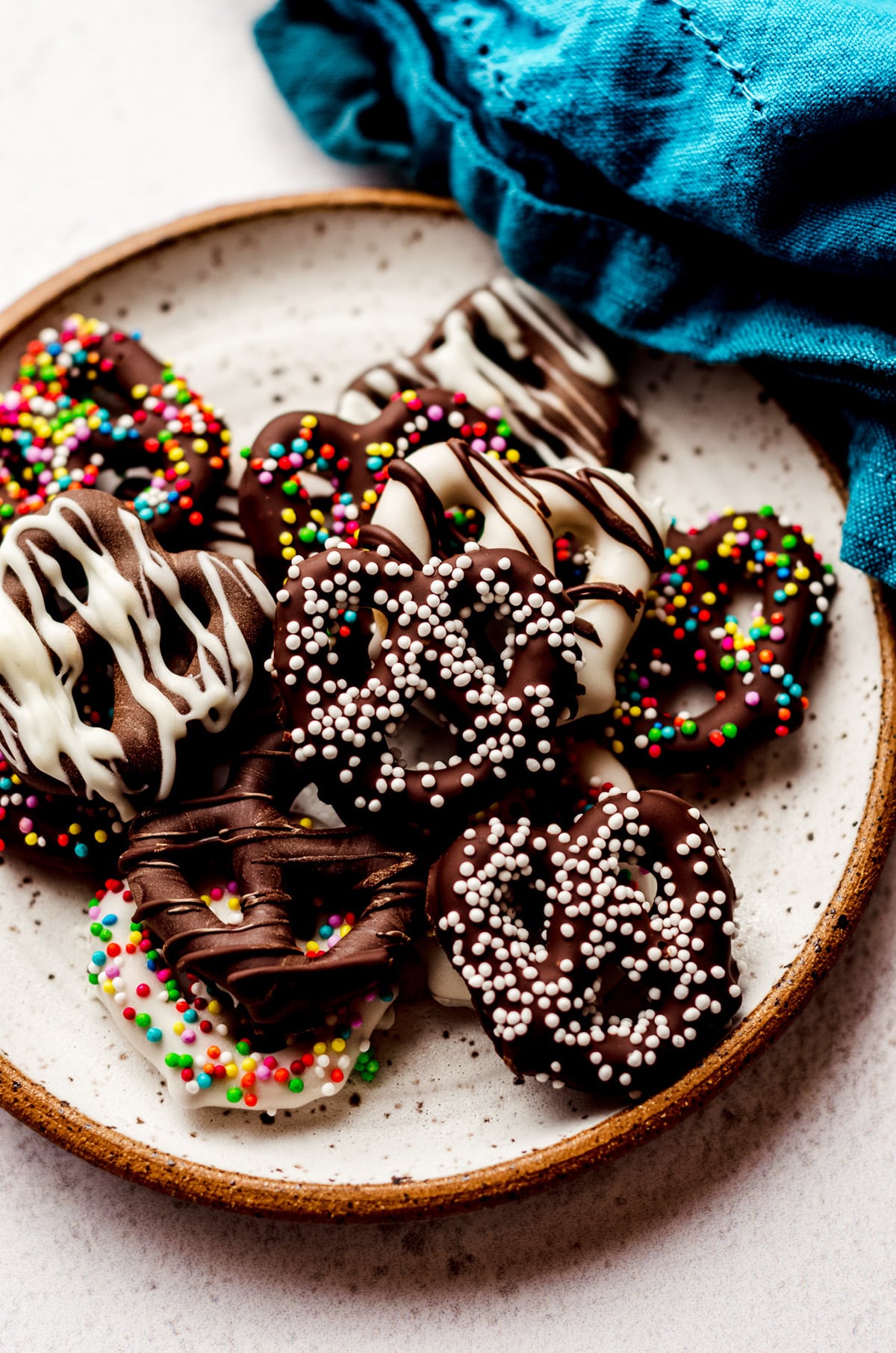 chocolate covered pretzels decorated with assorted sprinkles