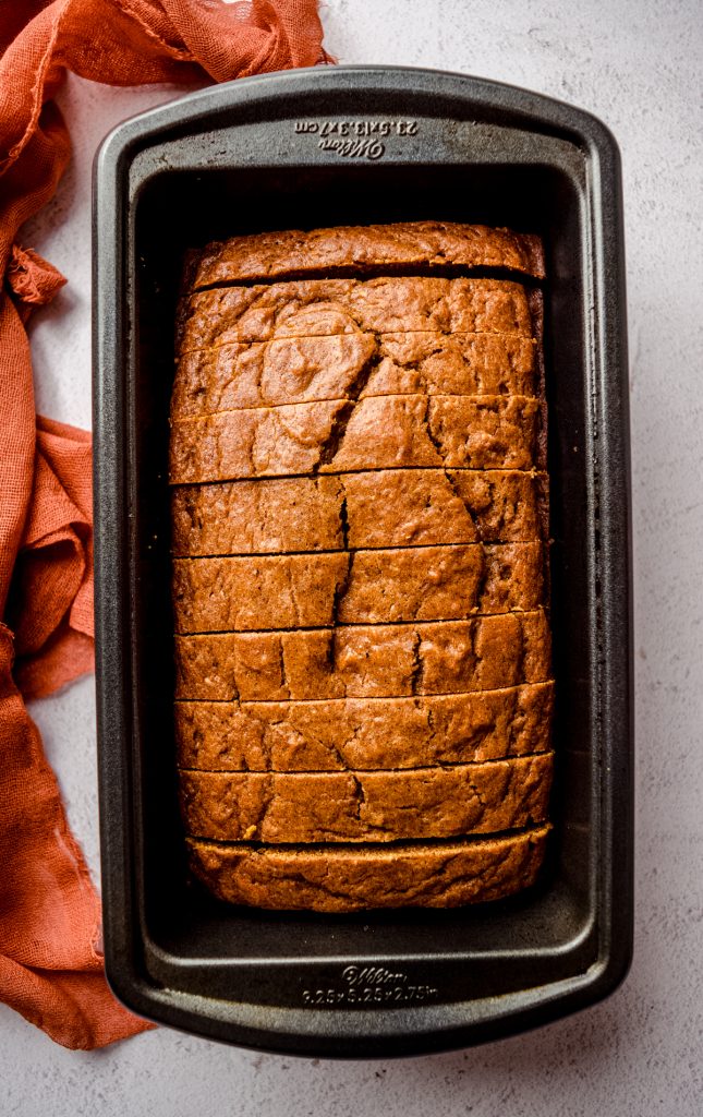 Aerial photo of pumpkin bread that has been sliced and set back into the loaf pan.