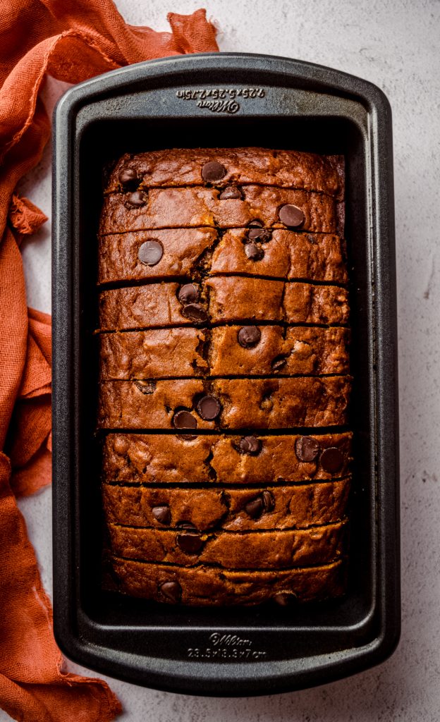 Aerial photo of pumpkin chocolate chip bread that has been sliced and set back into the loaf pan.