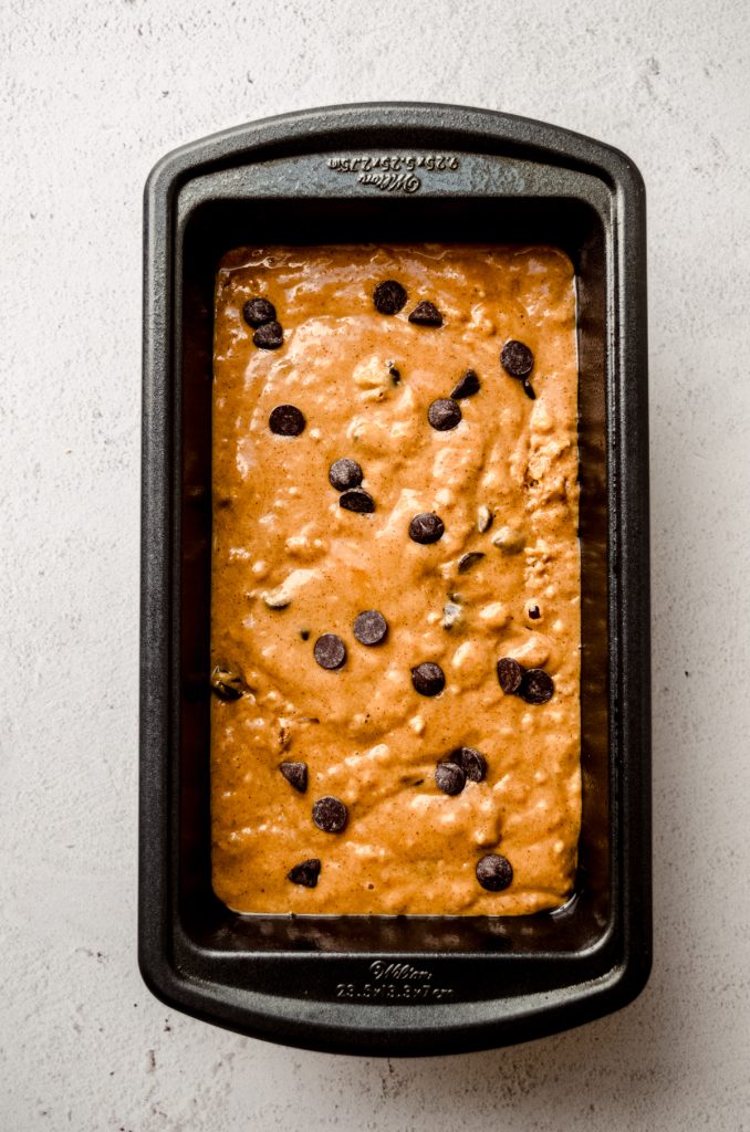 Aerial photo of pumpkin chocolate chip bread batter in a loaf pan.