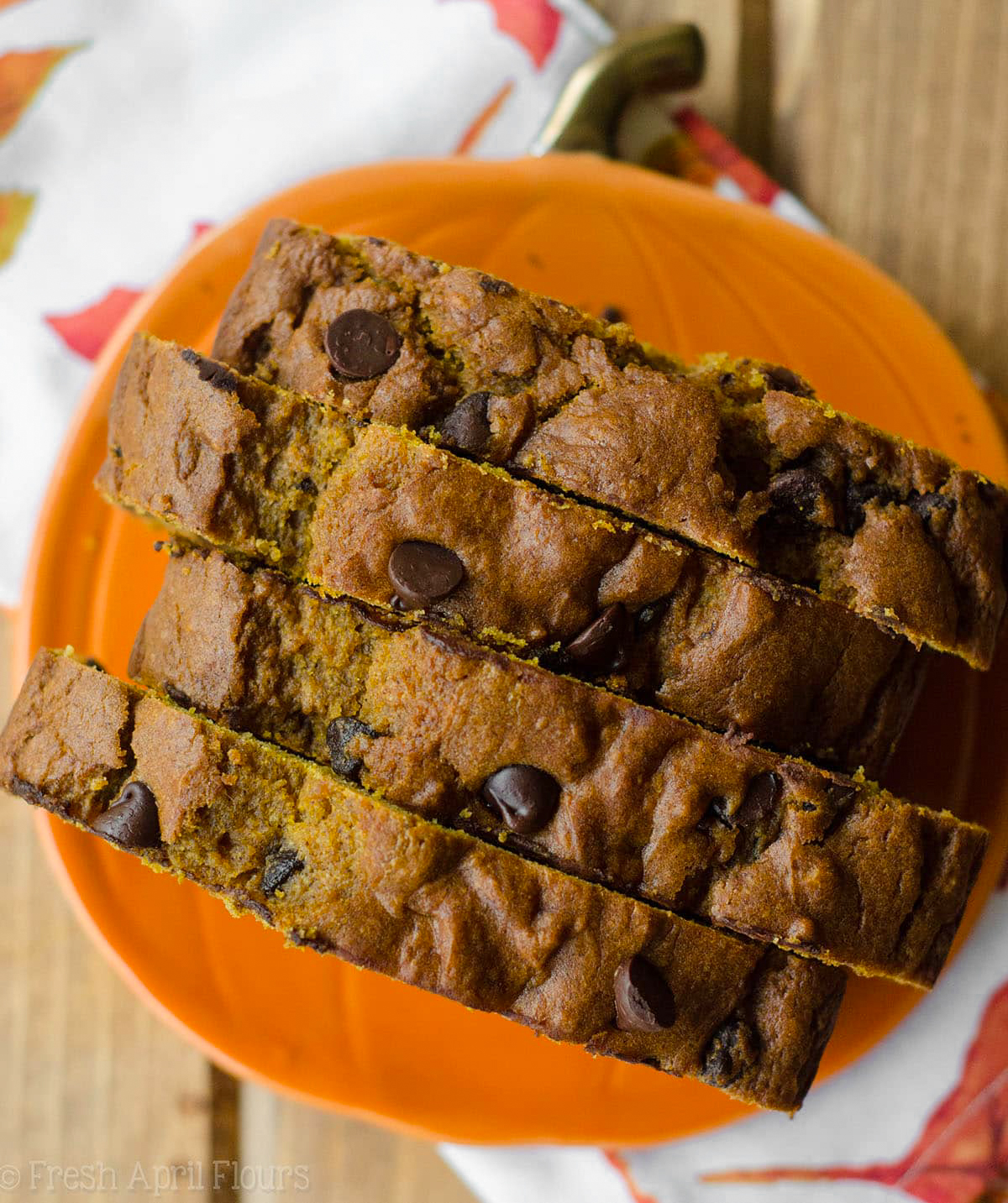 Aerial photo of slices of chocolate chip pumpkin bread on a pumpkin shaped plate.