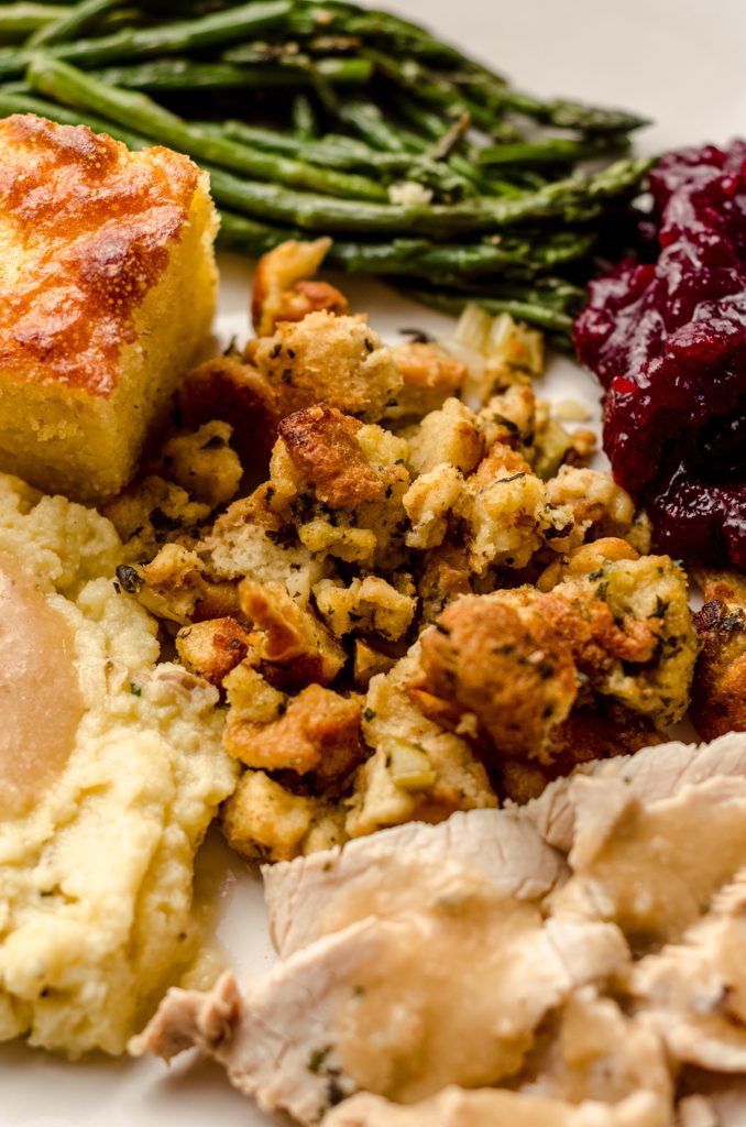 traditional bread stuffing on a plate with other thanksgiving sides