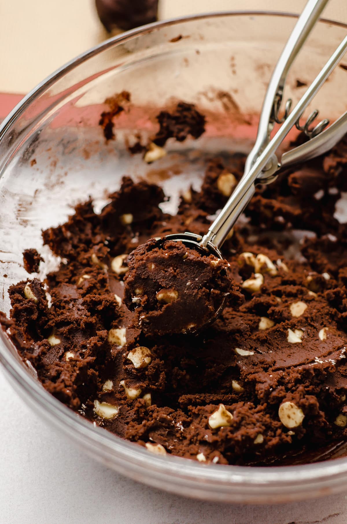 chocolate white chocolate chip cookie batter in a bowl with a cookie scoop