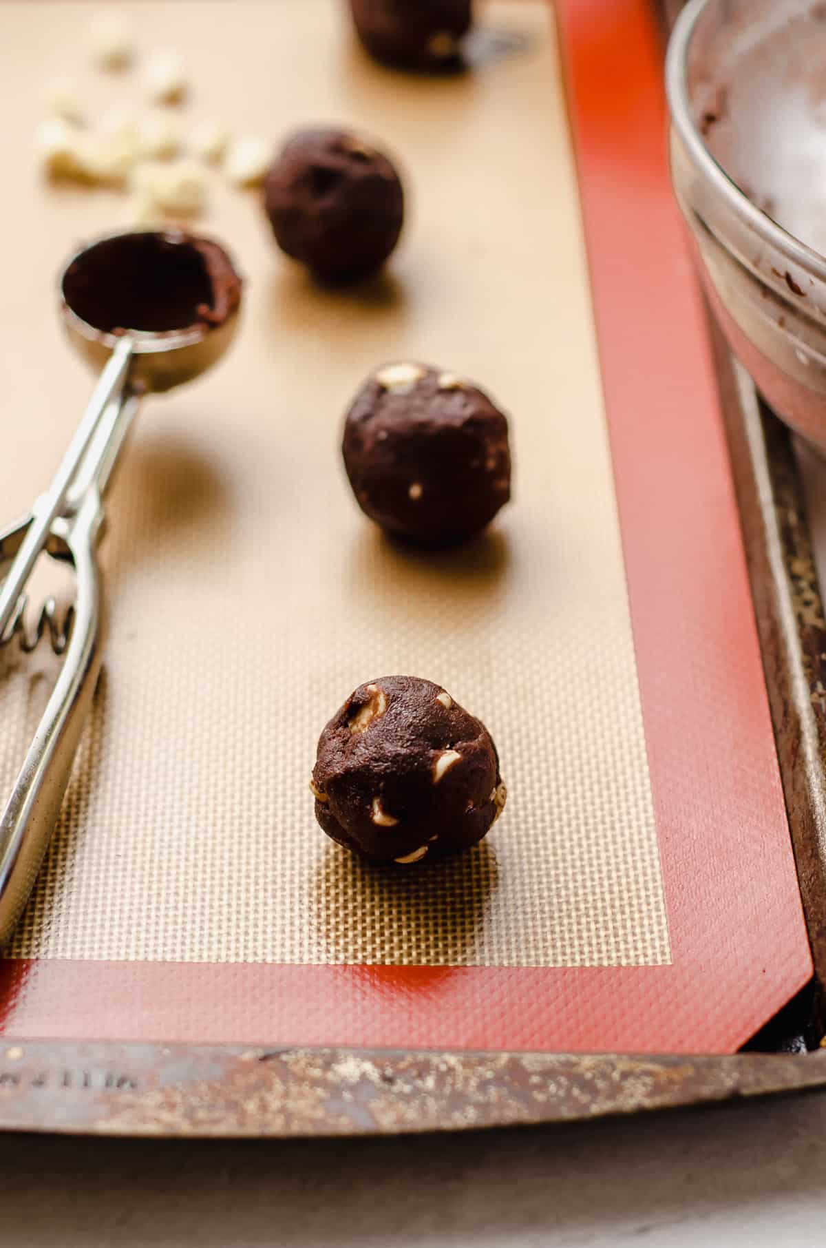chocolate white chocolate chip cookie dough balls on a baking sheet