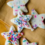 aerial photo of star shaped funfetti sugar cookies decorated with icing and rainbow sprinkles