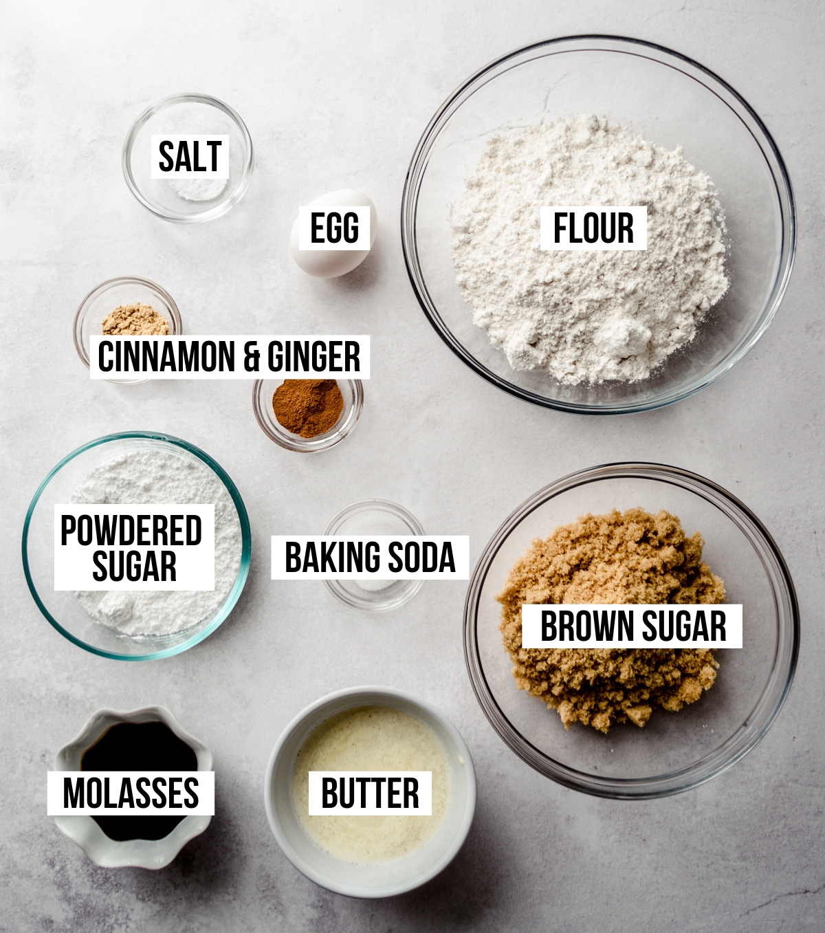 Aerial photo of ingredients to make gingerbread crinkle cookies with text overlay labeling each ingredient.