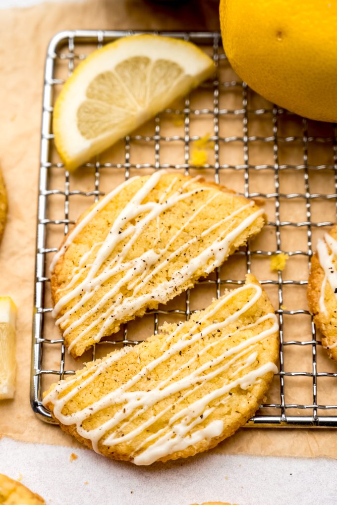 Aerial photo of a lemon pepper cookie that has been broken in half on a cooling rack.