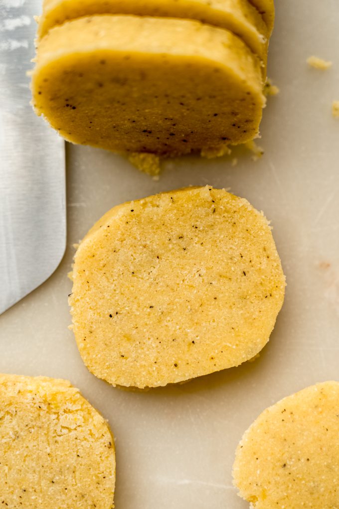 Lemon pepper slice and bake cookie dough shaped into a log and sliced into pieces to bake off cookies.