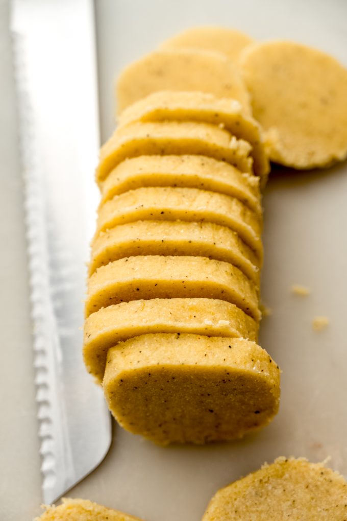 Lemon pepper slice and bake cookie dough shaped into a log and sliced into pieces to bake off cookies.