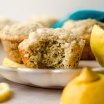 lemon poppy seed muffin on a plate with a bite taken out of it