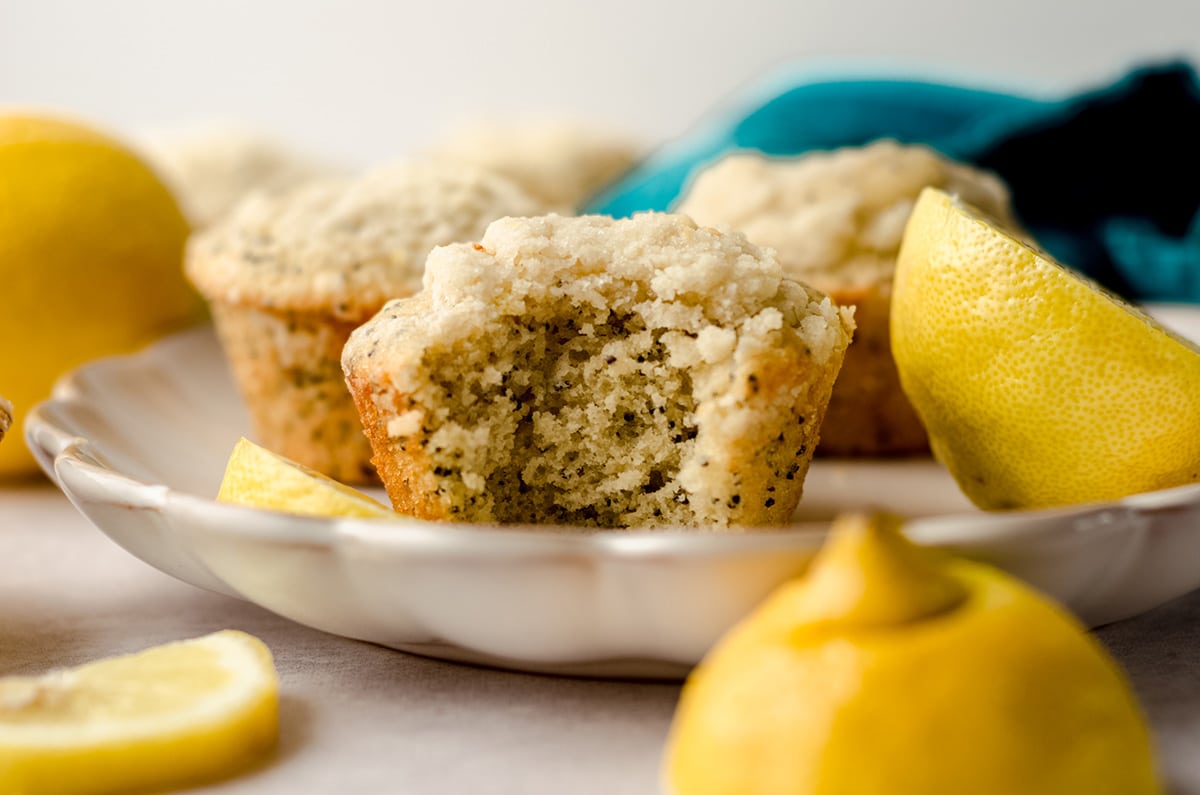 lemon poppy seed muffin on a plate with a bite taken out of it