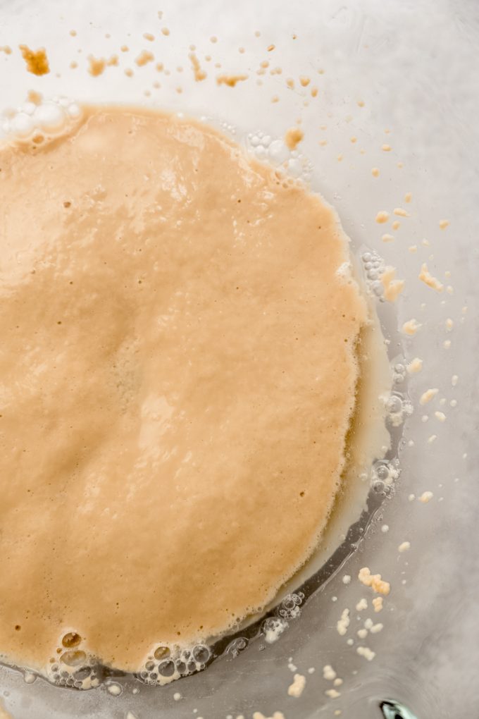 Proofed yeast in the bottom of a mixing bowl.
