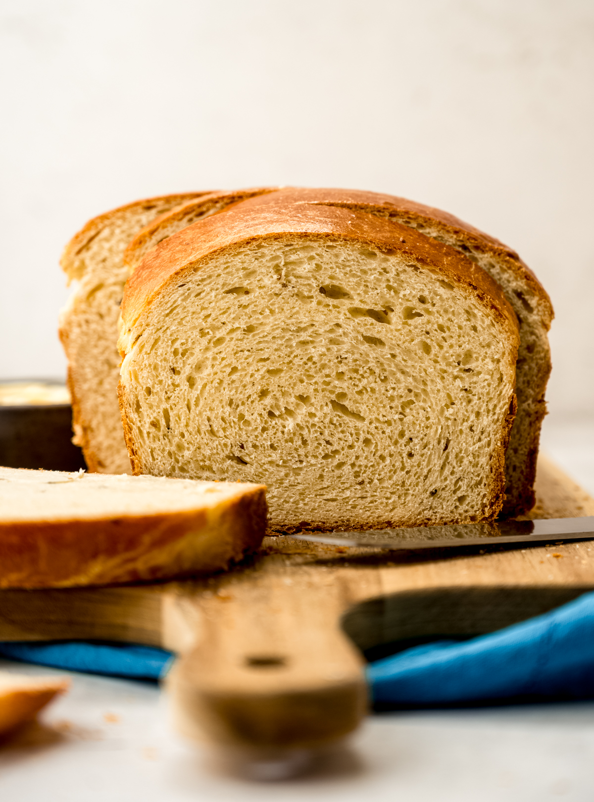 A photo of a sliced loaf of anise bread on a cutting board.