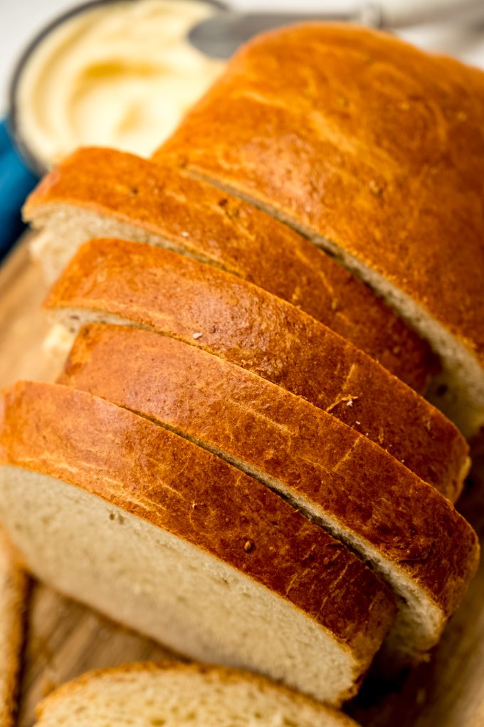 A photo of a sliced loaf of anise bread on a cutting board.
