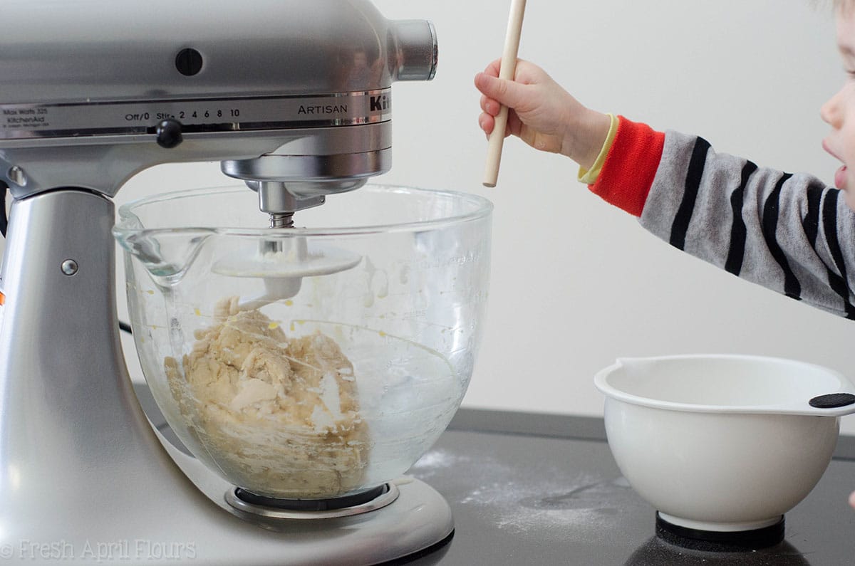 toddler helping make bread dough in a stand mixer