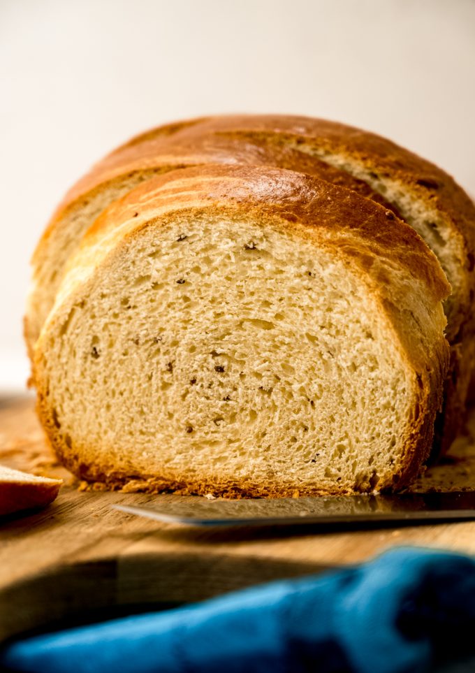 A photo of a sliced loaf of anise bread on a cutting board.