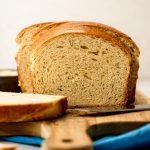 A photo of a sliced loaf of anise bread on a cutting board.