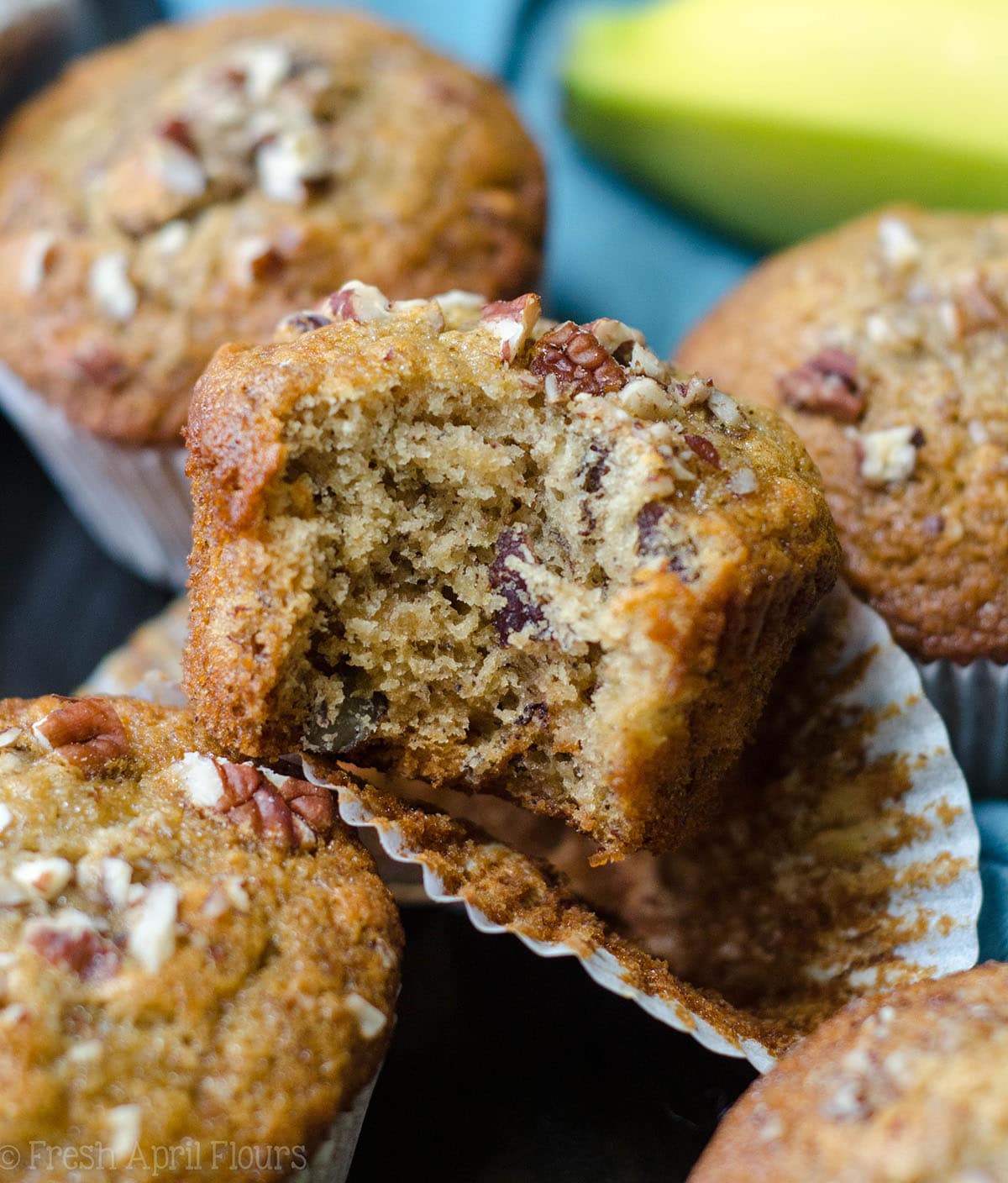 banana bread muffin sitting in a wrapper with a bite taken out of it