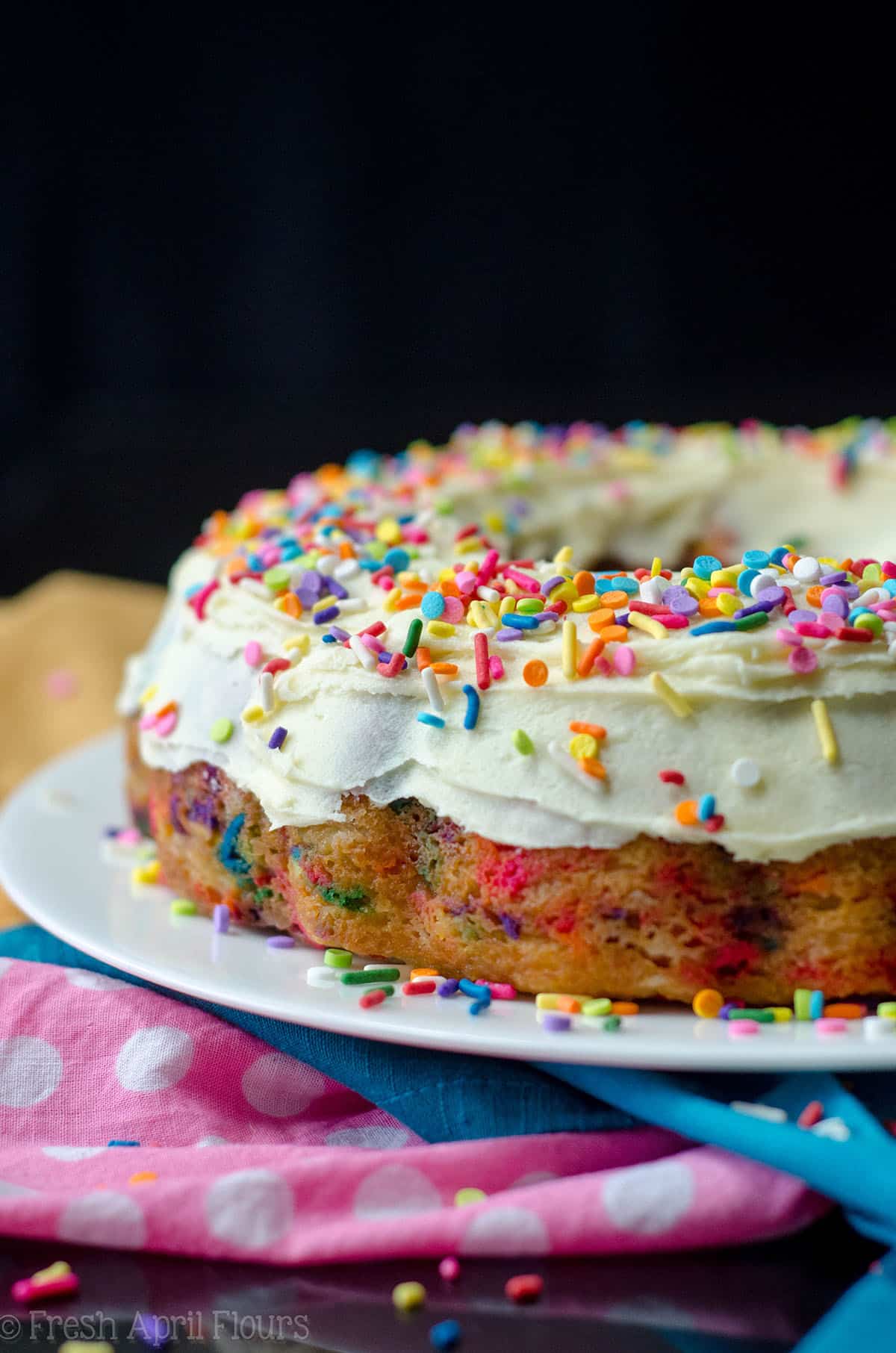 funfetti bundt cake with whipped white chocolate ganache frosting on a plate