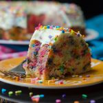 slice of funfetti bundt cake on a plate with sprinkles