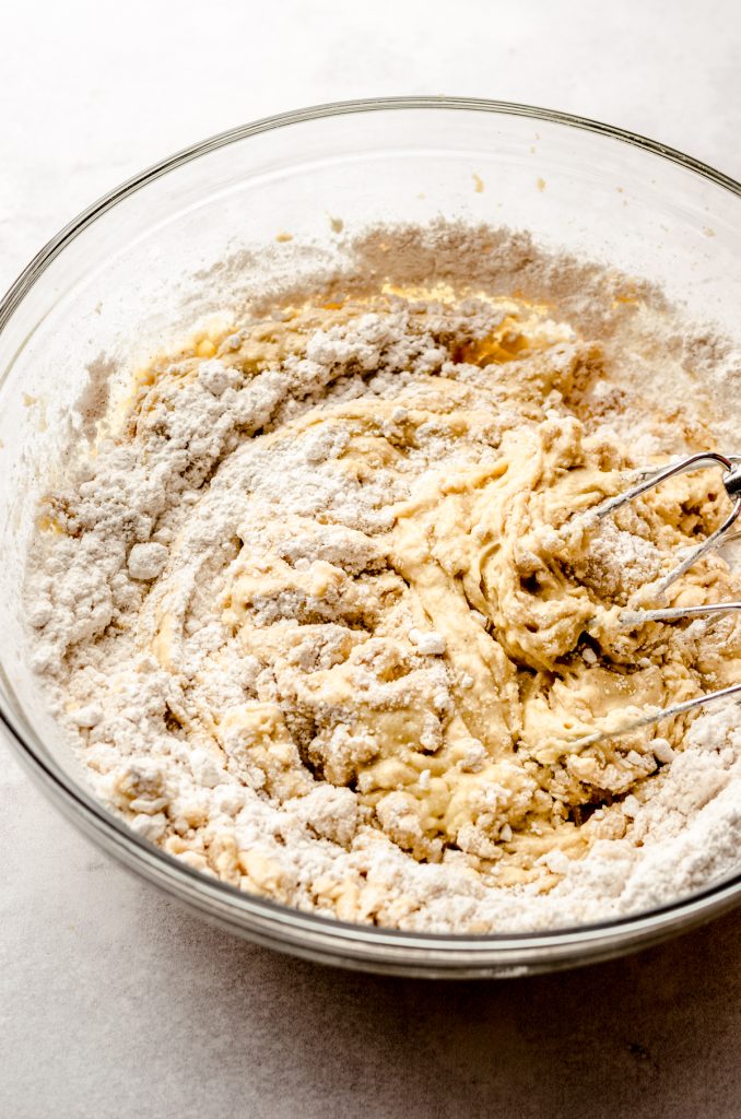 Cinnamon streusel coffee cake muffin batter coming together in a bowl with electric beaters.