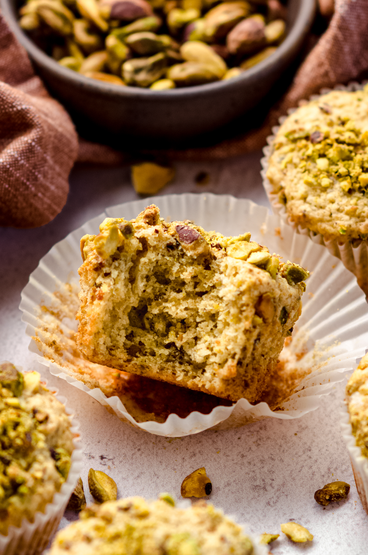 A pistachio muffin with a bite taken out of it.