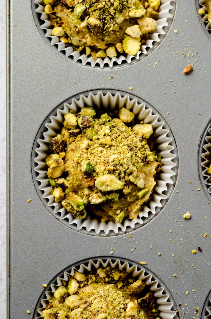 Aerial photo of pistachio muffin batter in a cupcake pan.
