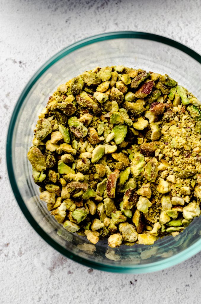 Aerial photo of a bowl of coarsely chopped pistachios.