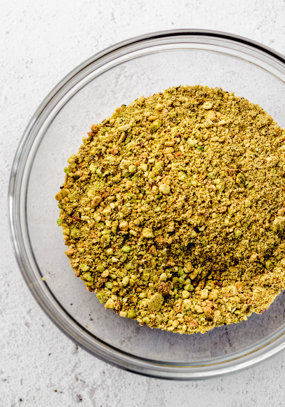 Aerial photo of finely crushed pistachios in a bowl.