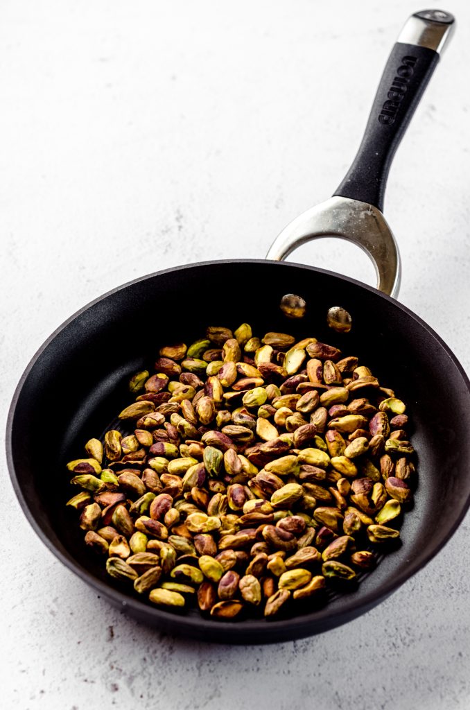 Toasted pistachios in a skillet.