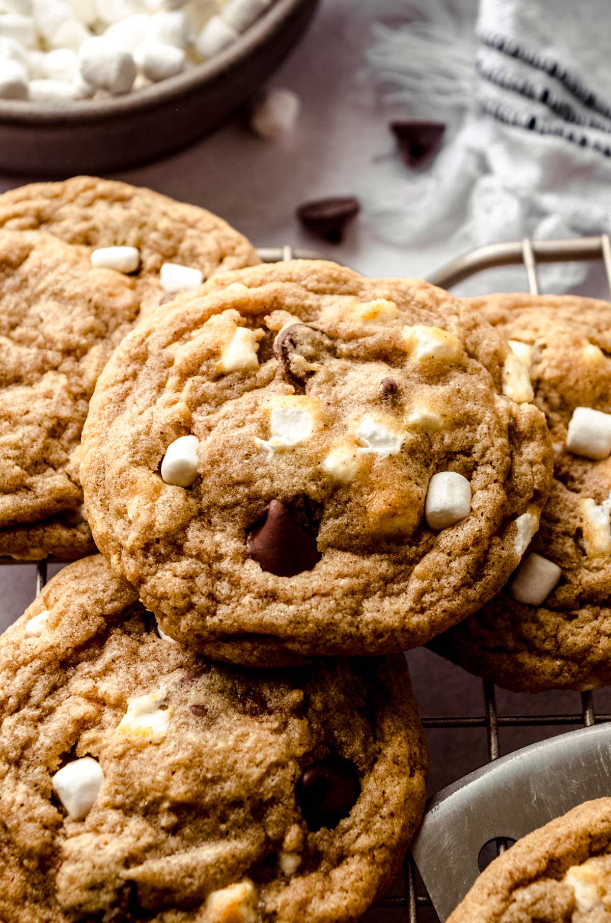 S'mores chocolate chip cookies stacked on a wire cooling rack.