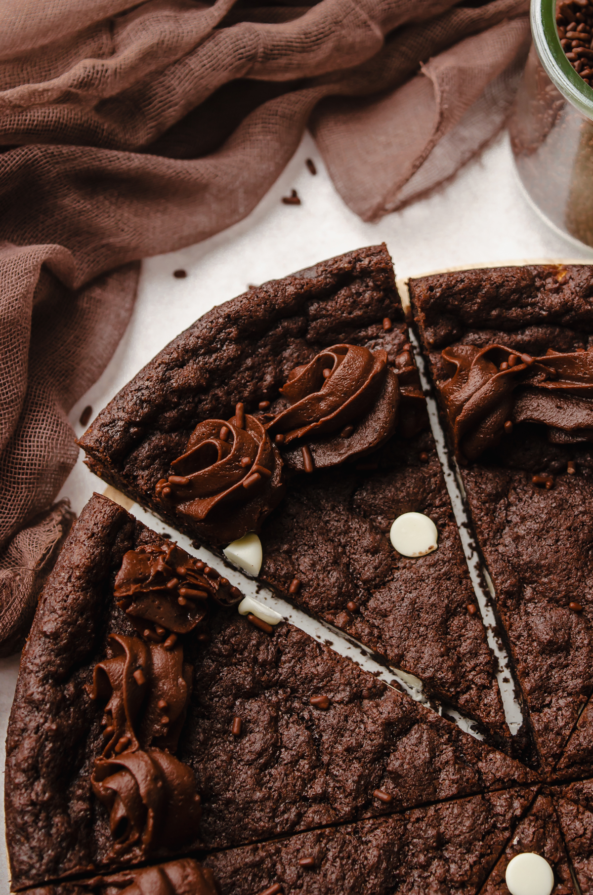 Aerial photo of a triple chocolate cookie cake that has been cut into slices.