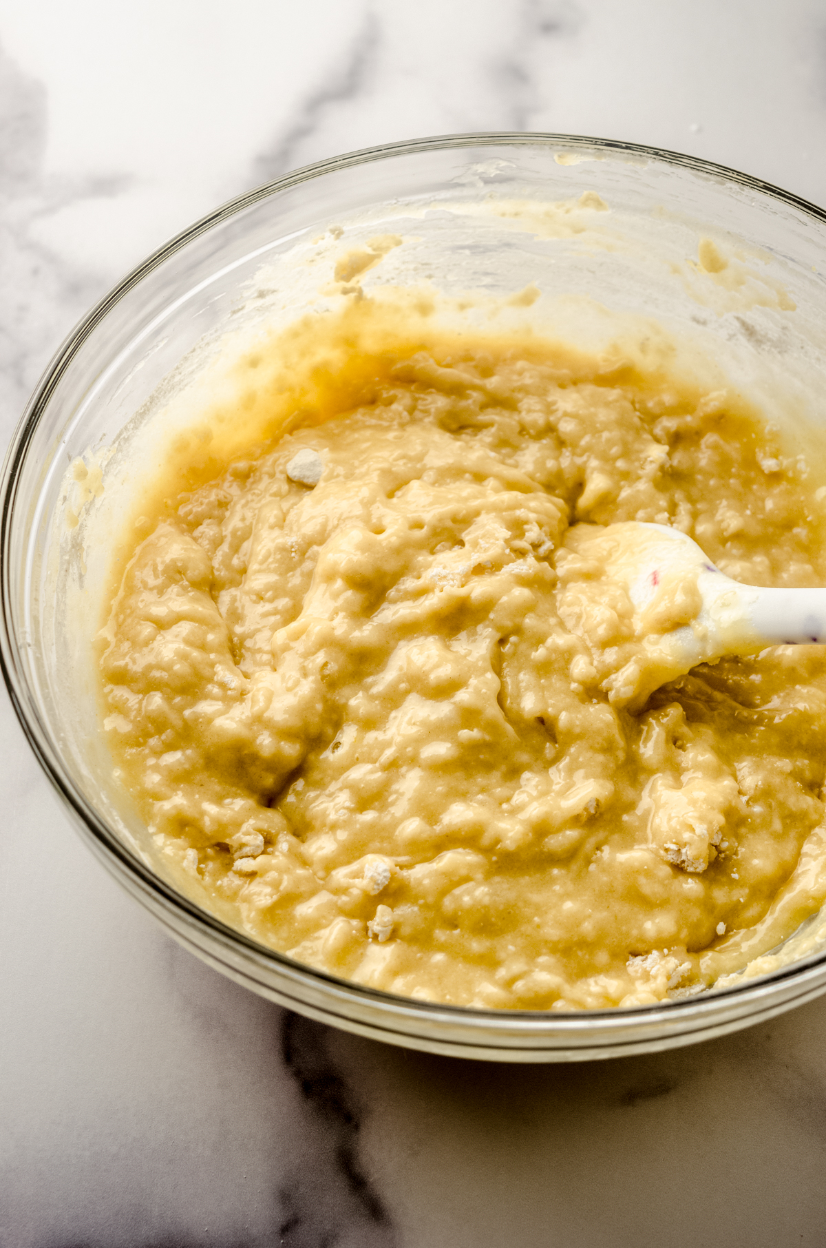 A bowl of muffin batter with a spatula.