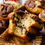 A Nutella muffin with a bite taken out of it on a surface.