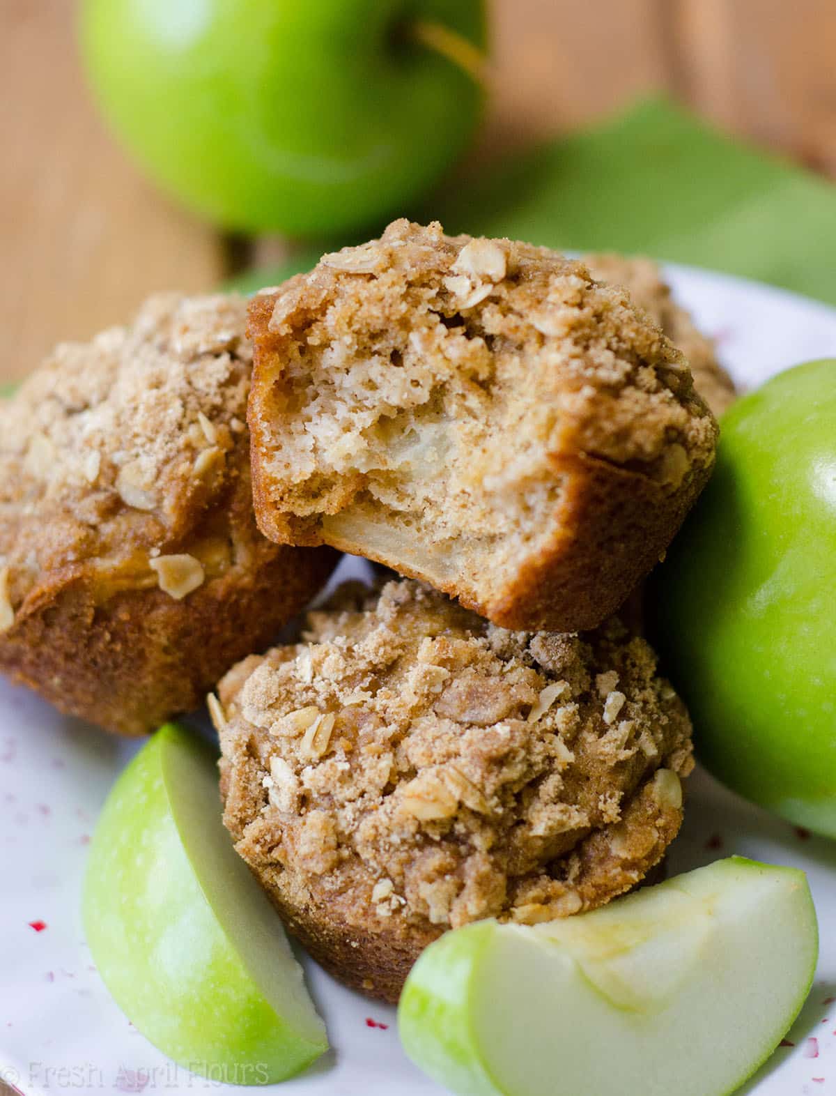 apple cinnamon oat streusel muffins with a bite taken out of one of them