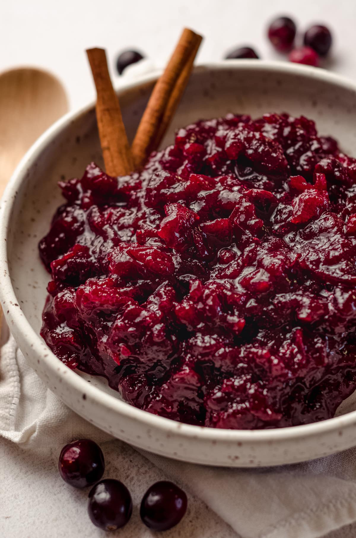 spiced cranberry sauce in a bowl with cinnamon sticks