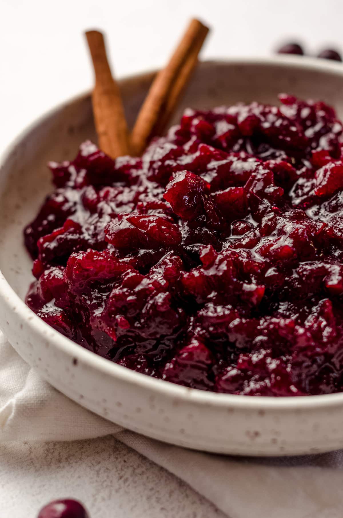 spiced cranberry sauce in a bowl with cinnamon sticks