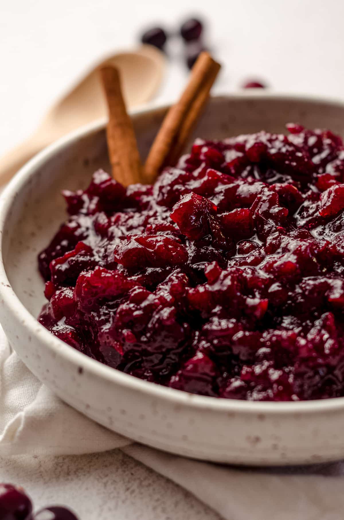 spiced cranberry sauce in a bowl with cinnamon sticks