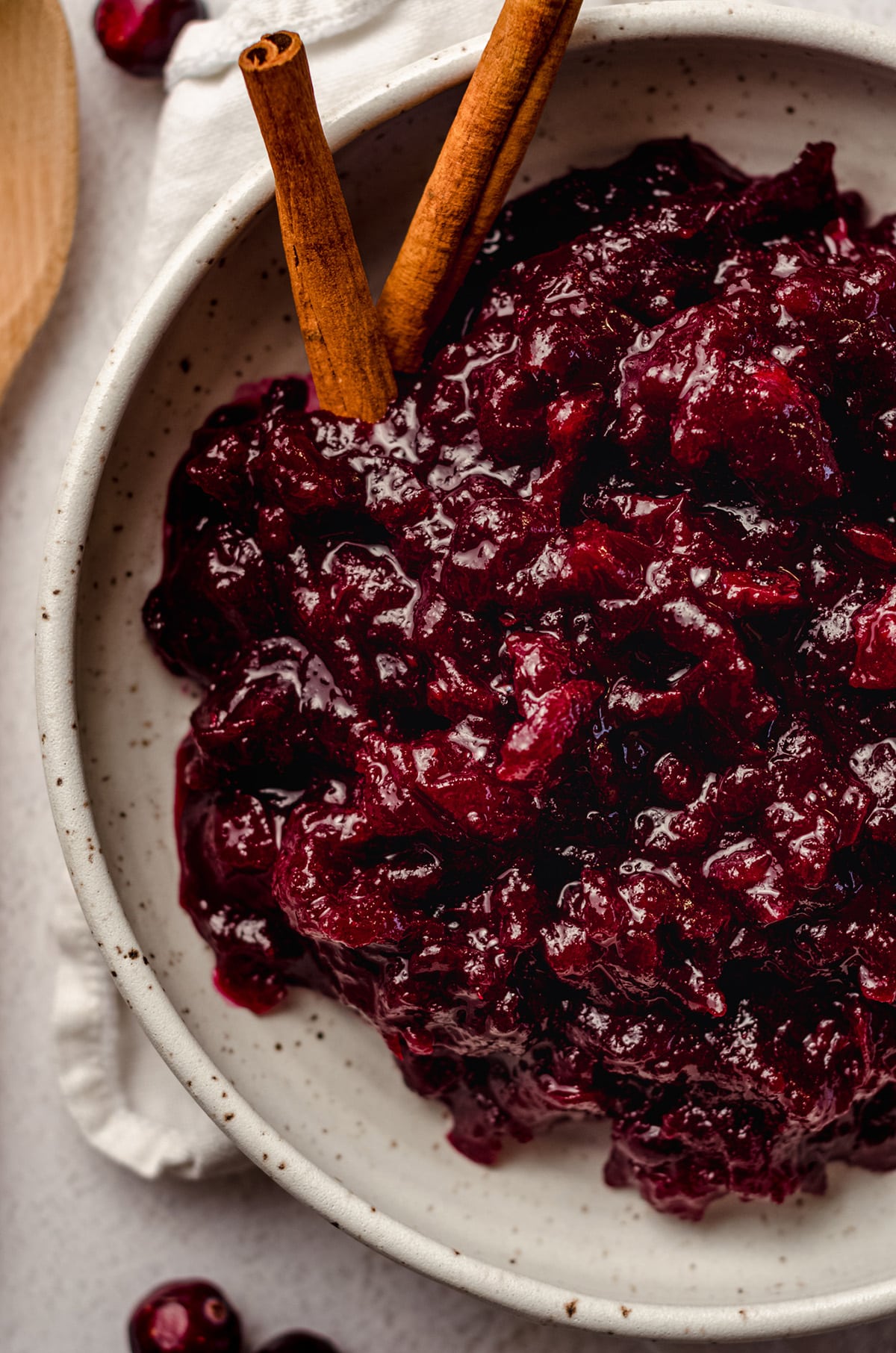 aerial photo of spiced cranberry sauce in a bowl with cinnamon sticks