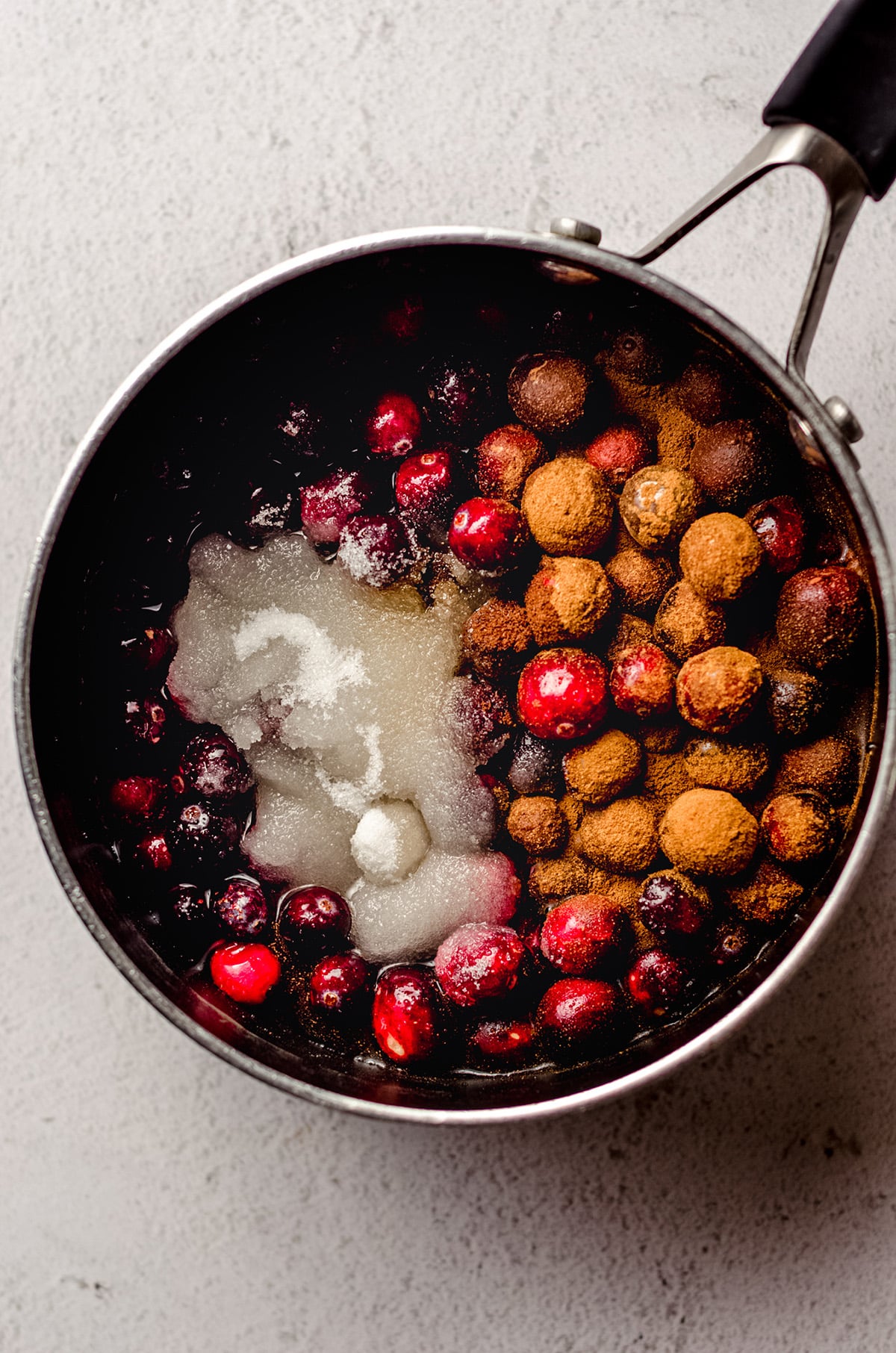 cranberries, sugar, and spices in a saucepan for spiced cranberry sauce