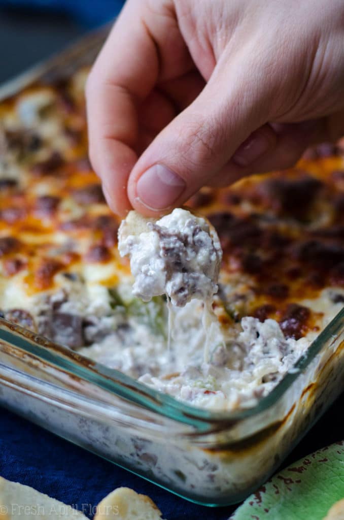 Philly Cheesesteak Dip: Creamy dip filled with flavorful onions, green pepper, mushrooms, and roast beef, topped with a crispy layer of provolone cheese.