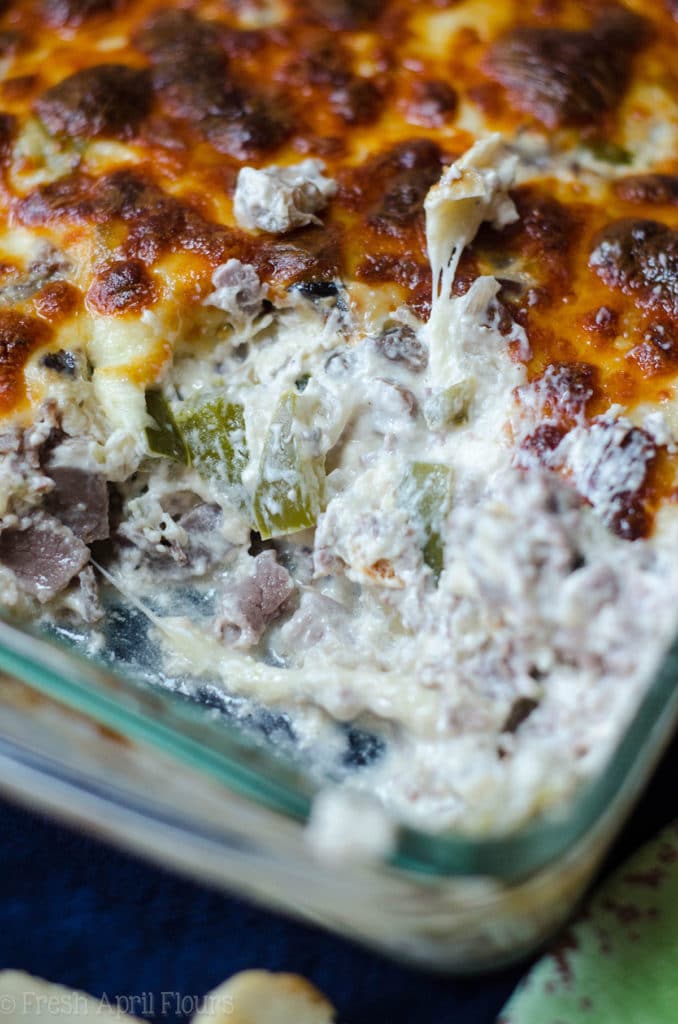 Philly Cheesesteak Dip: Creamy dip filled with flavorful onions, green pepper, mushrooms, and roast beef, topped with a crispy layer of provolone cheese.