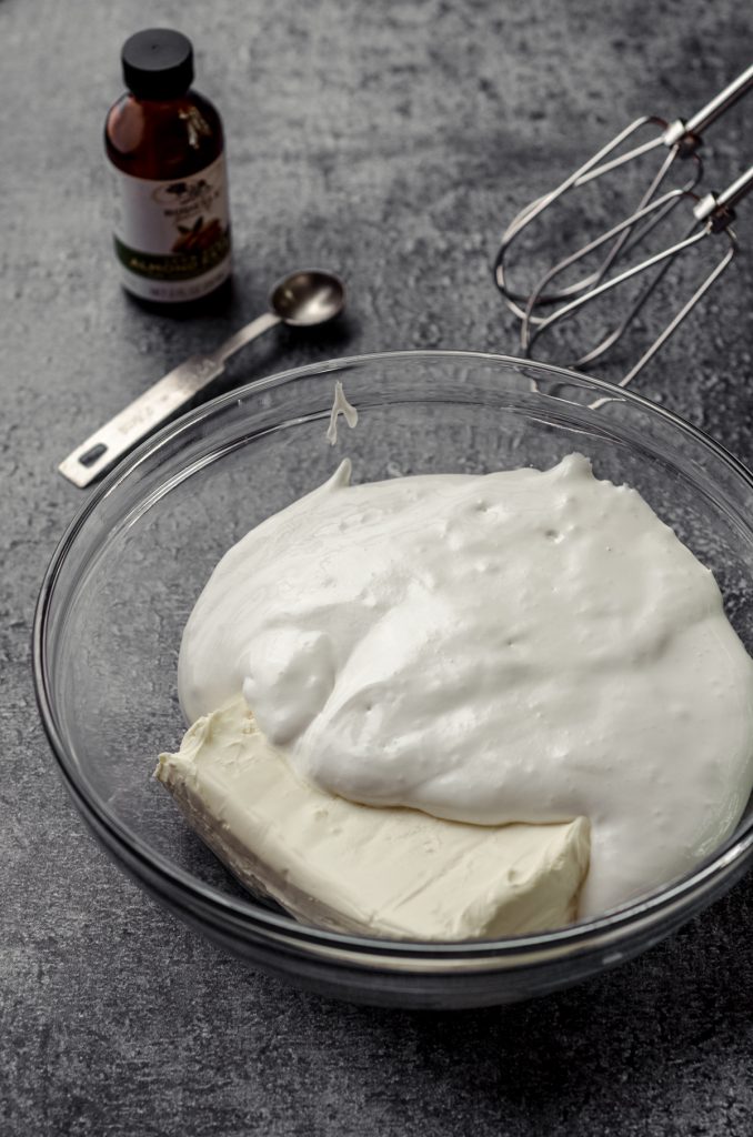 Cream cheese and fluff in a bowl with beaters ready to make fruit dip.