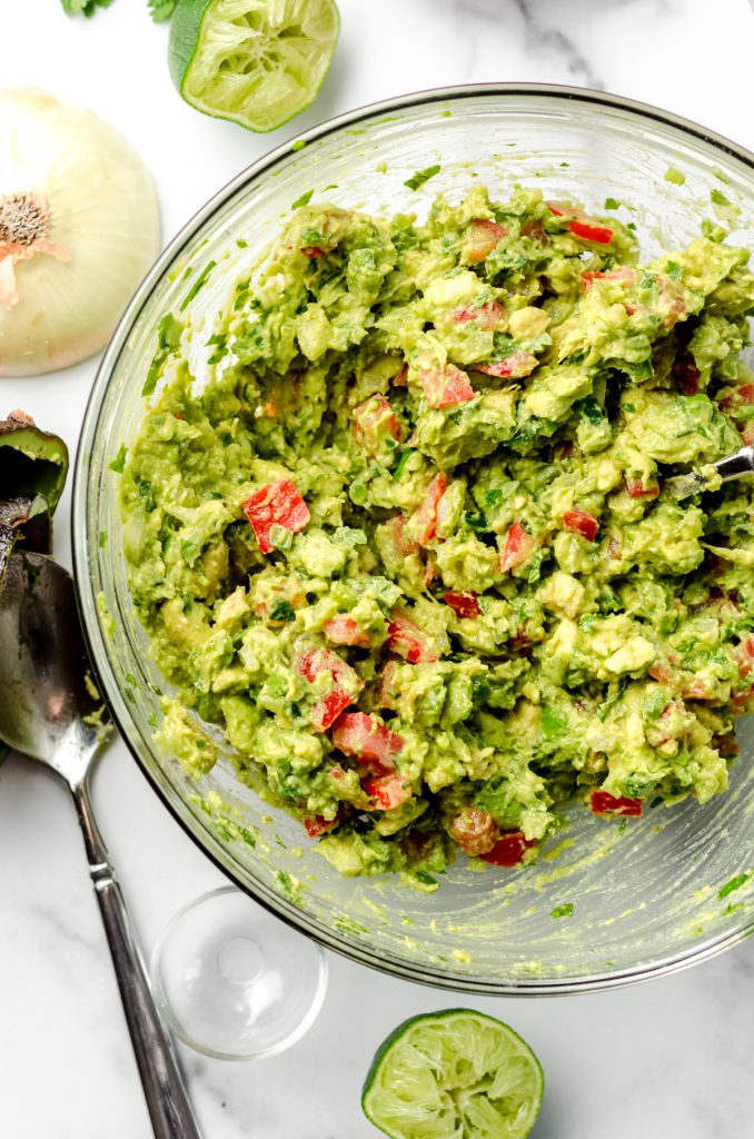 Homemade guacamole in a large glass bowl.