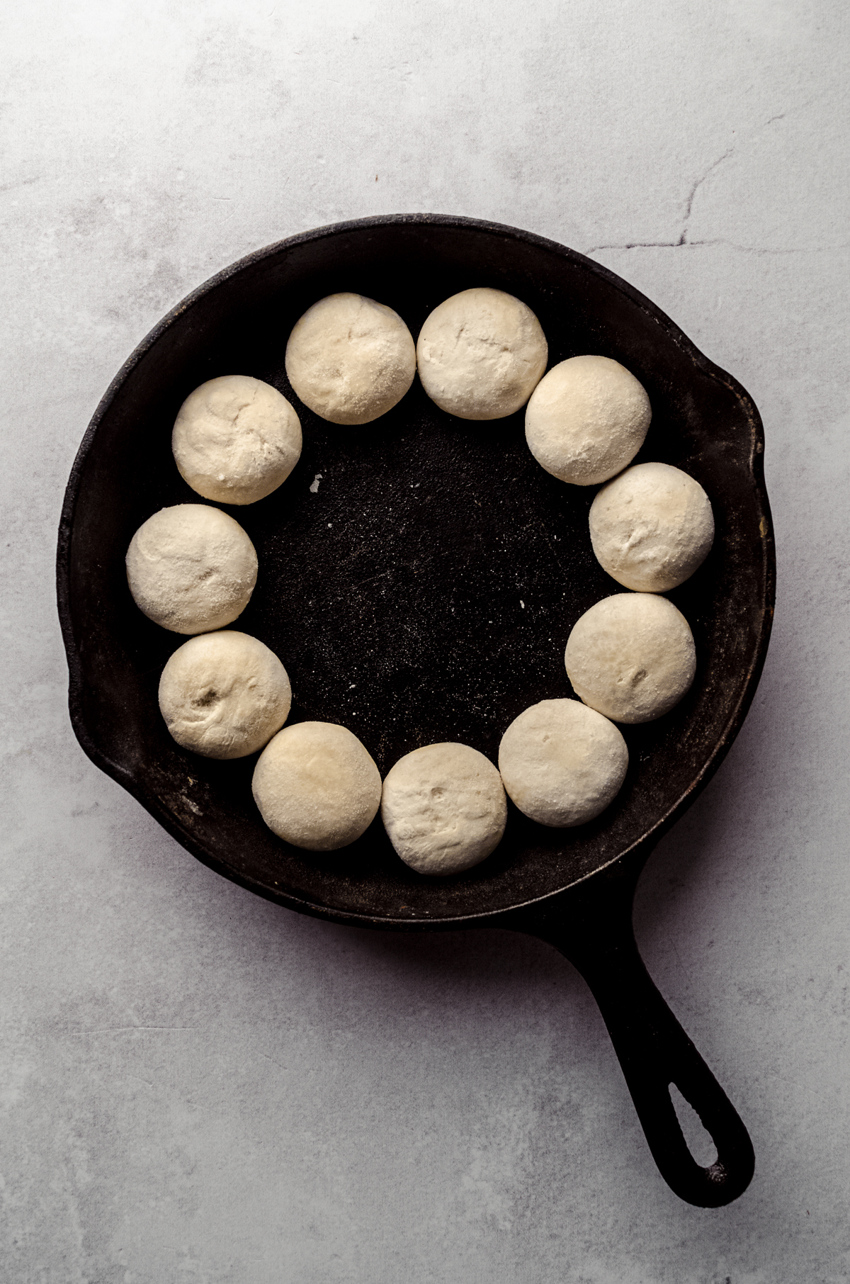 A skillet has been lined with frozen dinner rolls to make pizza dip.