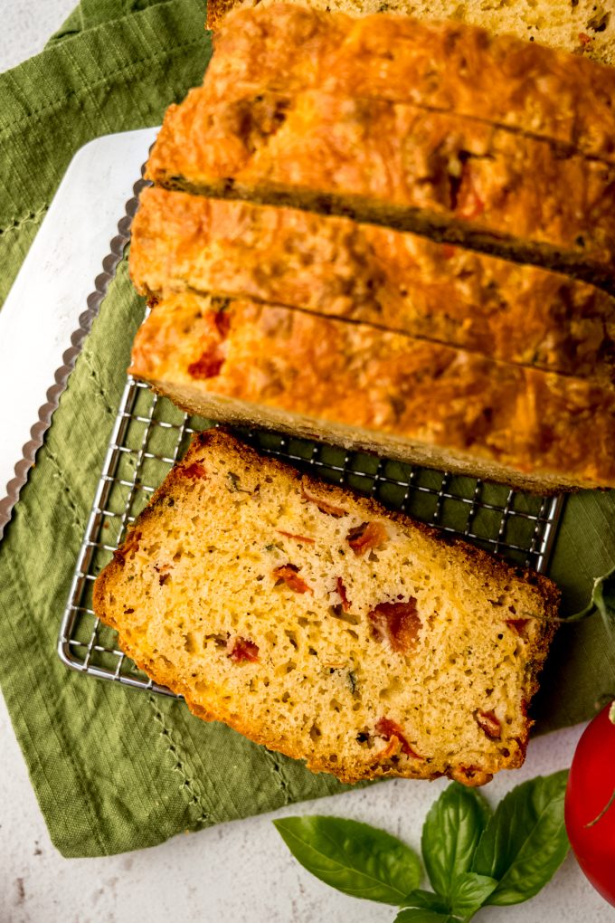 Sliced tomato basil bread on a surface.