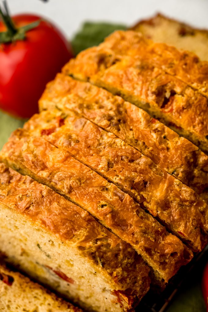Sliced tomato basil bread on a surface.