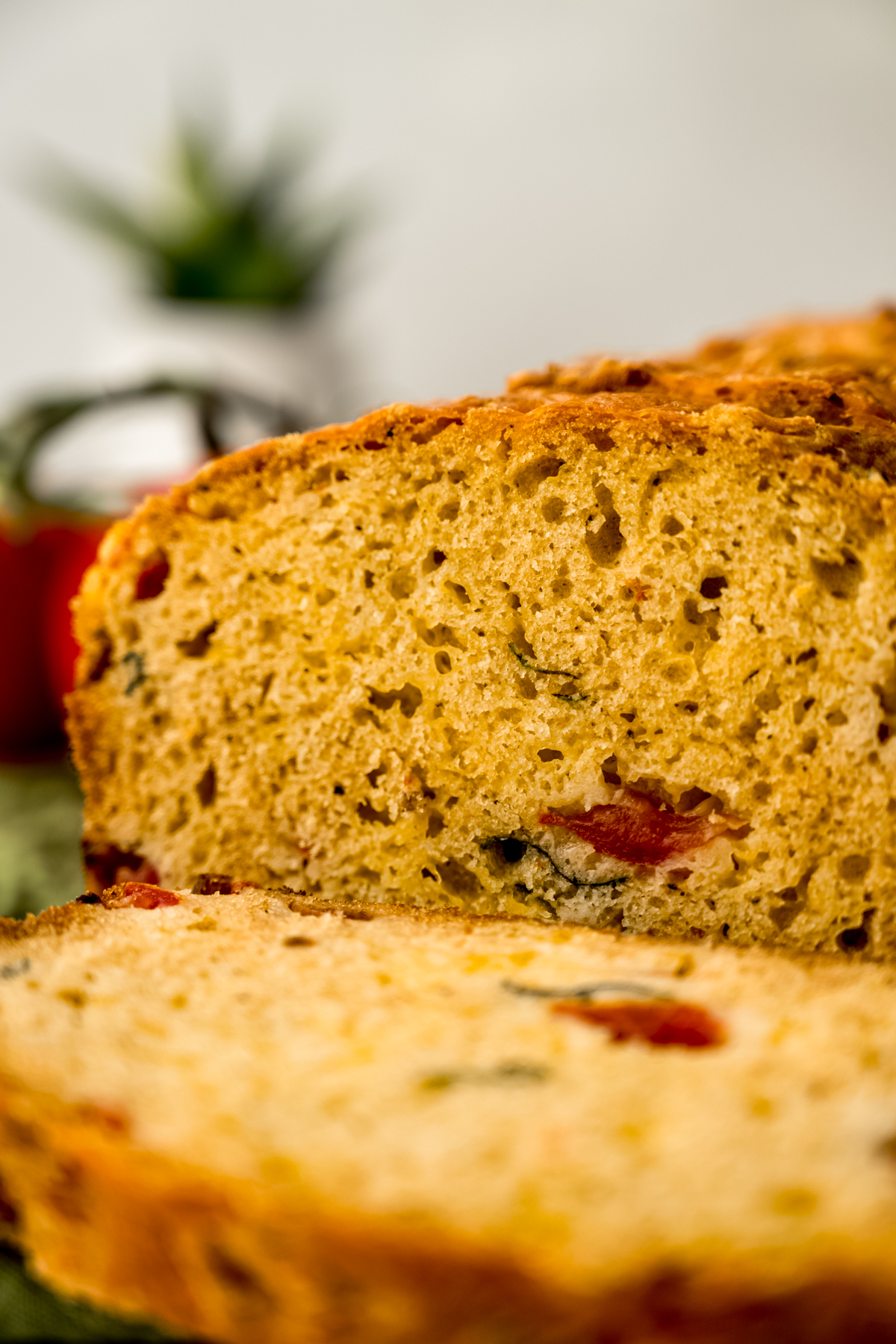 Sliced tomato basil bread on a surface.